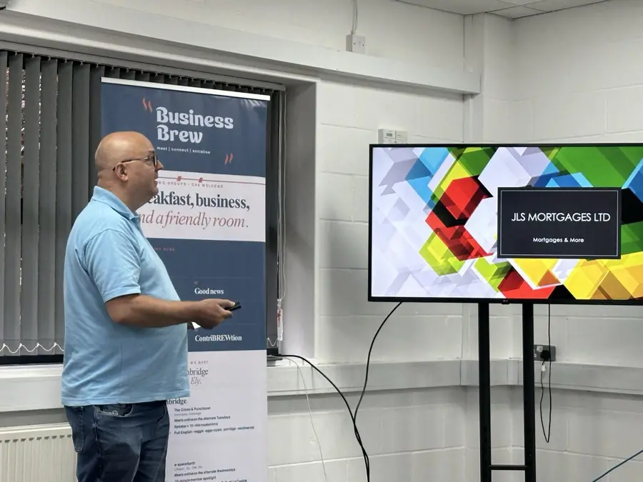 Adam presenting next to the Business Brew banner while a member's slides show on the screen