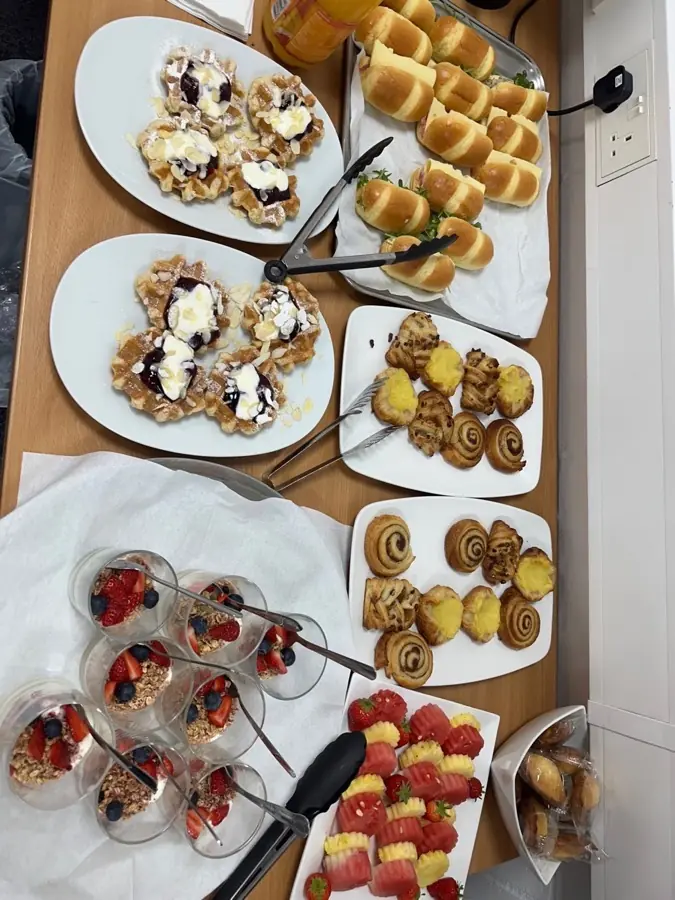 The whole breakfast spread laid out at eSpace North: waffles, pastries, granola pots, fruit and hot cross buns